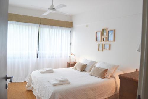 1 dormitorio con 1 cama blanca y 2 toallas en Welcome to Tigre en Tigre