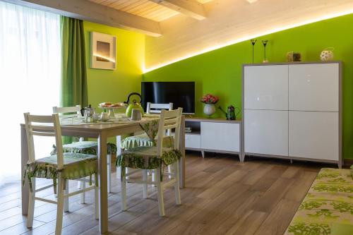 ein Esszimmer mit einem Tisch, Stühlen und einem TV in der Unterkunft Il Sopracciglio Suites - Green Suite in Cassino