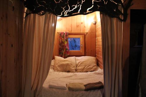 ein kleines Bett in einem Zimmer mit Fenster in der Unterkunft Les Insolites du Vercors in Saint-Paul-lès-Monestier