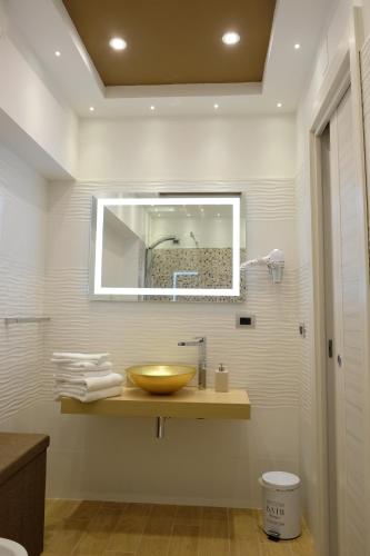 a bathroom with a bowl sink and a mirror at B&B Rossini Luxury in Rende
