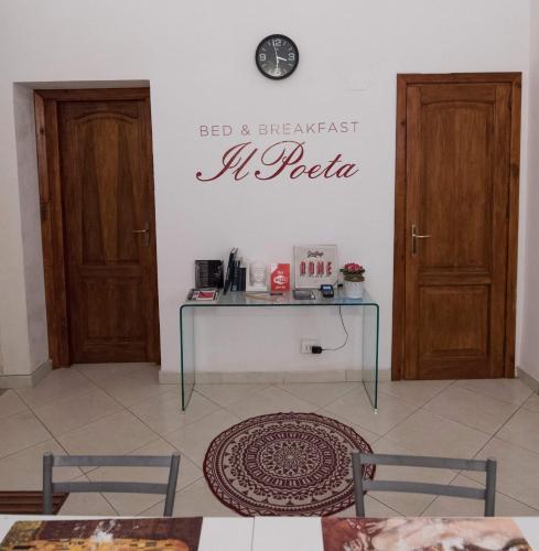 a room with two doors and a table with a clock on the wall at B&B IL POETA in Palermo