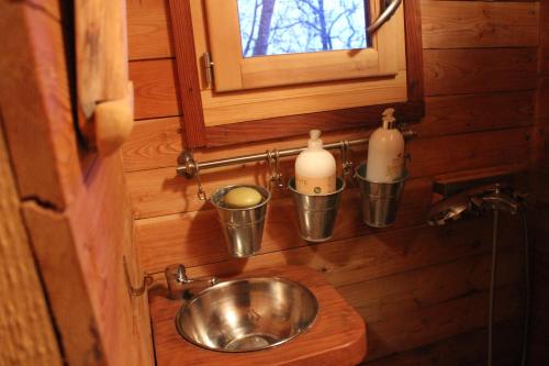 ein kleines Bad mit einem Waschbecken und zwei Flaschen in der Unterkunft Les Insolites du Vercors in Saint-Paul-lès-Monestier