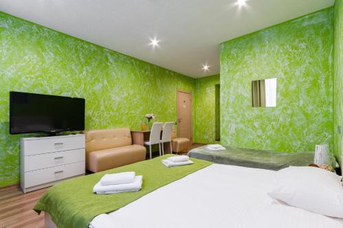 a bedroom with a large bed and a flat screen tv at Mini Hotel Pomestie in Saint Petersburg