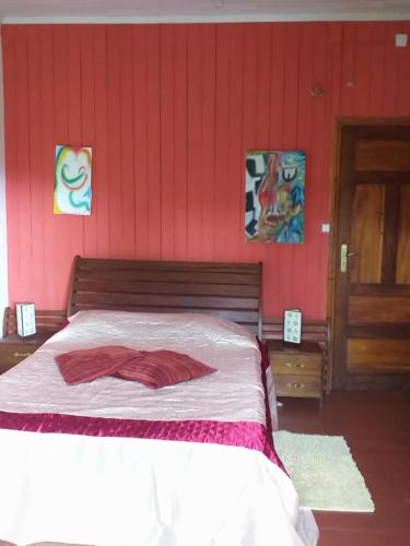 a bedroom with a bed with a red wall at Casa modelo Colonial - Guest House Quinta Natural in Graça