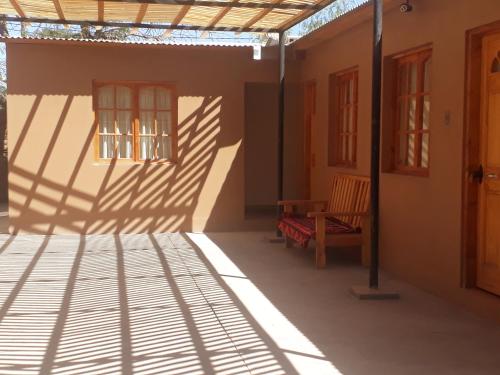 ein Schatten eines Hauses mit einer Bank und einem Fenster in der Unterkunft CASA MACAW in San Pedro de Atacama