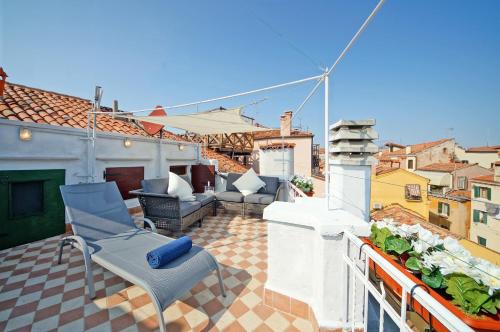 eine Terrasse mit Stühlen und einem Kamin auf dem Dach in der Unterkunft Best Venice Terrace in Venedig