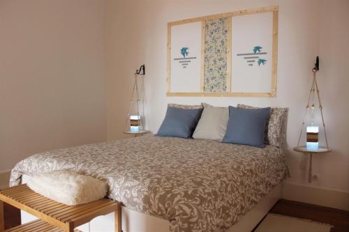 um quarto com uma cama com almofadas azuis e uma janela em Retrato de Lisboa em Lisboa