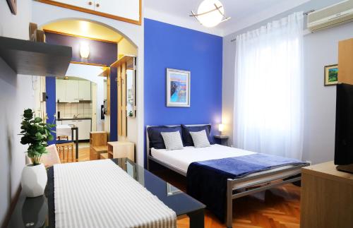 ein Schlafzimmer mit einem Bett und einer blauen Wand in der Unterkunft SPLIT CHIC Studio in Split