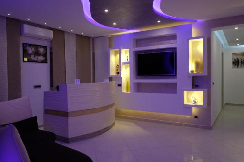 a purple room with a couch and a tv at B&B Rossini Luxury in Rende