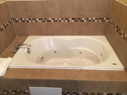 a white bath tub sitting inside of a bathroom at The Island House Hotel in Port Clinton