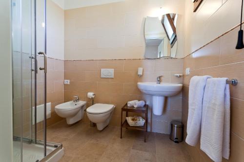 uma casa de banho com um WC, um lavatório e um espelho. em Hotel La Campana em Casarano