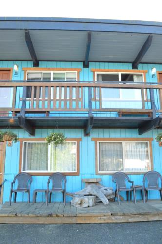 a blue building with a table and chairs and a balcony at Meares Vista Inn in Tofino