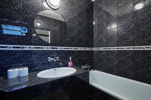 a bathroom with a sink and a mirror and a tub at Holiday houses BARCA in Košice