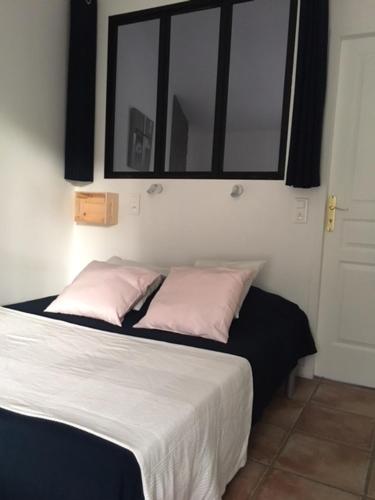 - un lit avec 2 oreillers roses dans une chambre dans l'établissement Gîte des lavandes, à Montagnac