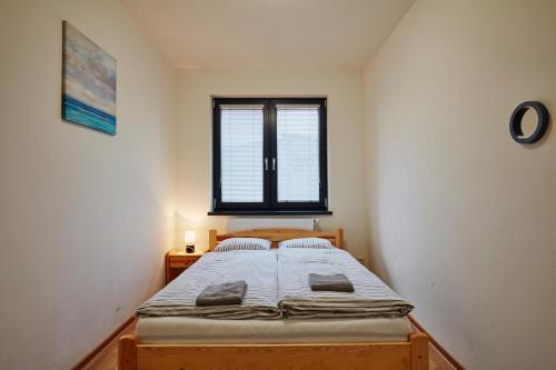 a bedroom with a bed in a room with a window at Holiday houses BARCA in Košice