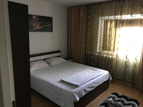 a small bedroom with a bed and a window at Apartament Port Turistic Mangalia in Mangalia