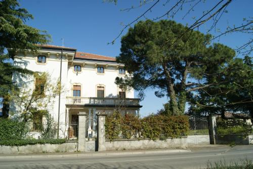 a white house with a fence and a tree at Il Bozzolo Eco Boutique Apartments in Valeggio sul Mincio