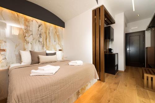 a bedroom with a bed with towels on it at Tsikeli Boutique Hotel Meteora - Adults Friendly in Kalabaka