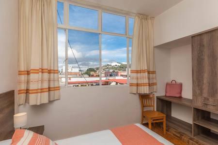 - une chambre avec un lit et une grande fenêtre dans l'établissement Bienvenidos to Oaxaca (8), à Oaxaca
