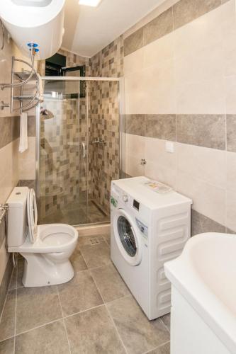 a bathroom with a toilet and a washing machine at Dunja Boka Bay in Herceg-Novi