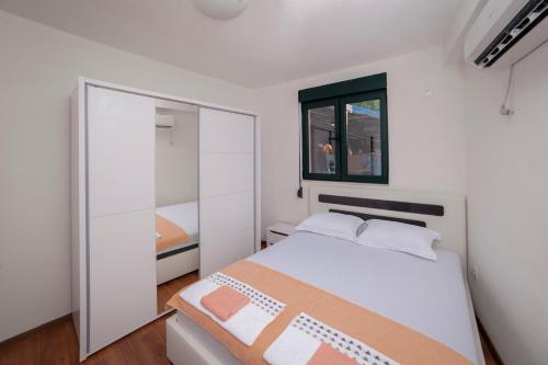a white bedroom with a bed and a mirror at Dunja Boka Bay in Herceg-Novi