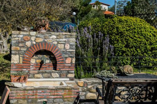 a stone fireplace in a yard with a table at Feggaropetra by the Sea(Moonstone) - Trani Ammouda in Ormos Panagias