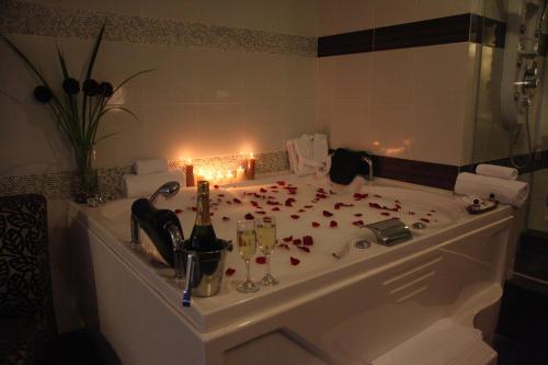 a bathroom with a tub filled with red rose petals at Hotel Rivera Inn in Lima
