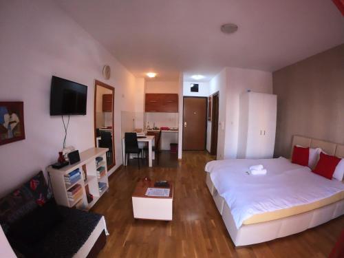 ein Schlafzimmer mit einem Bett und ein Wohnzimmer in der Unterkunft Apartment Bono 1 City Kvart in Podgorica