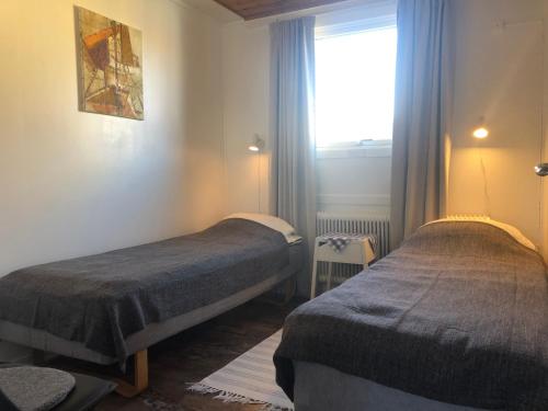 two beds in a room with a window at Kajsa krabbat Vandrarhem in Kungshamn