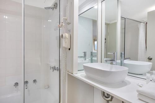 雪梨的住宿－Renovated Stylish Studio，白色的浴室设有水槽和淋浴。