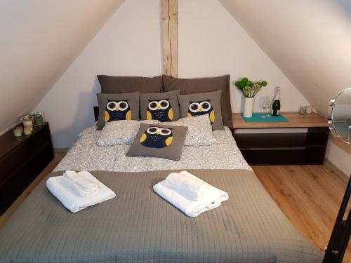 a bedroom with a bed with two owls pillows at GRAFIT in Mrzeżyno