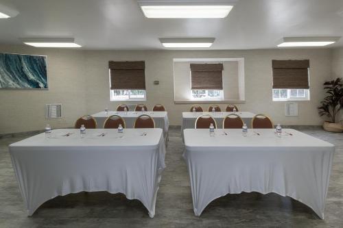 a set of tables with chairs in a room at Ramada by Wyndham Costa Mesa/Newport Beach in Costa Mesa