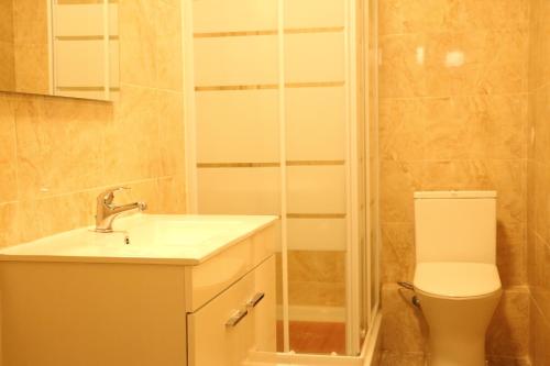 y baño con aseo, lavabo y ducha. en The Delight Hostel, en Lisboa
