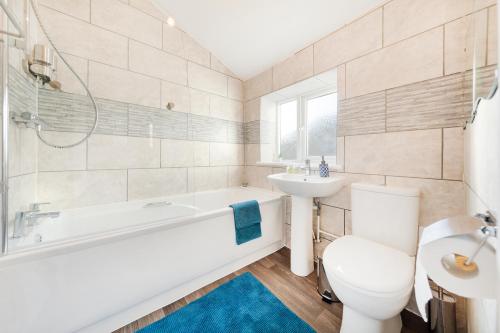 a bathroom with a tub and a toilet and a sink at Remi Martin's Place in Bristol