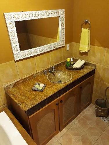 a bathroom with a sink and a mirror at Luxury Suites Vila Indonésia in Garopaba