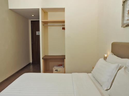 a bedroom with a white bed in a room at d'primahotel ITC Mangga Dua in Jakarta