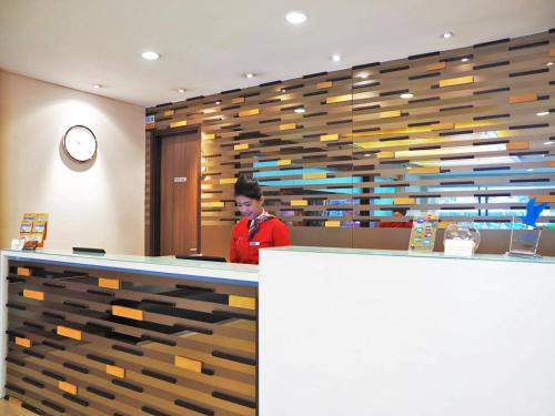 a man standing at a counter in a store at d'primahotel ITC Mangga Dua in Jakarta
