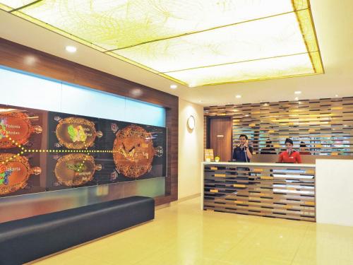 a restaurant with a counter with clocks on the wall at d'primahotel ITC Mangga Dua in Jakarta
