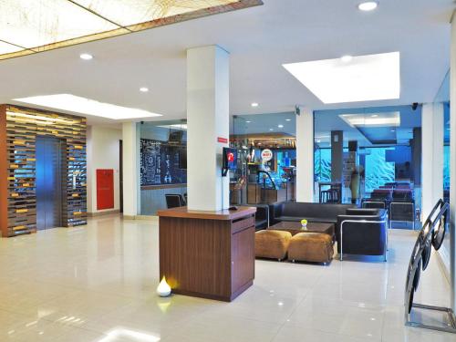 a lobby with a couch and a column in a building at d'primahotel ITC Mangga Dua in Jakarta