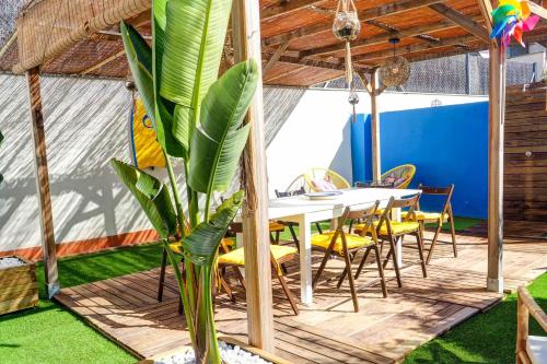 une salle à manger avec une table, des chaises et une plante dans l'établissement The Beach House Paradise by Hello Homes Sitges, à Sitges