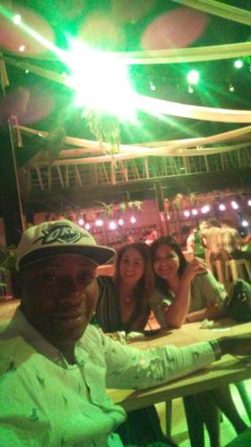 a man standing in front of a bar with two women at Rolando share apart in Punta Cana