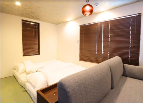 a living room with a white couch and a window at BETTEI Yamashiro (別邸 山代) in Kaga