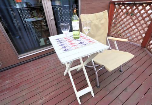 a white table with two glasses and a bottle of wine at BETTEI Yamashiro (別邸 山代) in Kaga