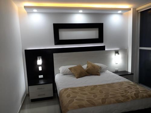 a bedroom with a large bed with two pillows at FONTAINE BLEAU in Tonsupa