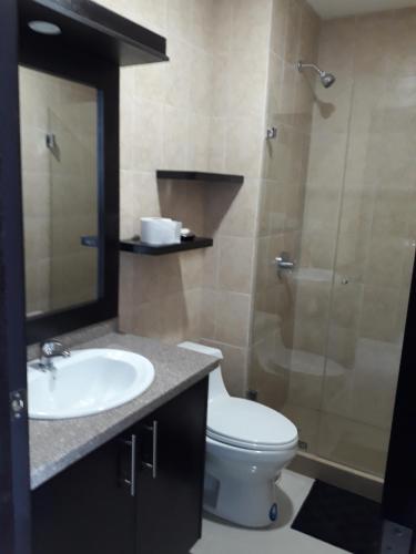 a bathroom with a toilet and a sink and a shower at FONTAINE BLEAU in Tonsupa