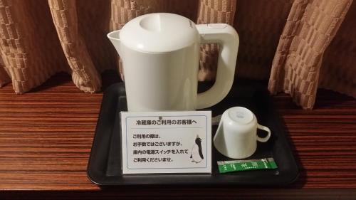 a tray with a coffee maker and a cup on it at Hotel Onahama Hills in Iwaki