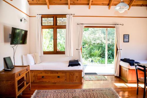 ein Schlafzimmer mit einem Bett und einem großen Fenster in der Unterkunft The Church Accommodation in Hahei