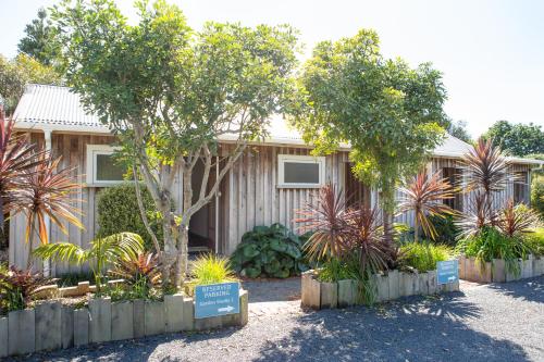 a house with a bunch of plants in front of it at The Church Accommodation in Hahei