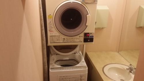 eine Waschmaschine im Bad neben einem Waschbecken in der Unterkunft Hotel Onahama Hills in Iwaki