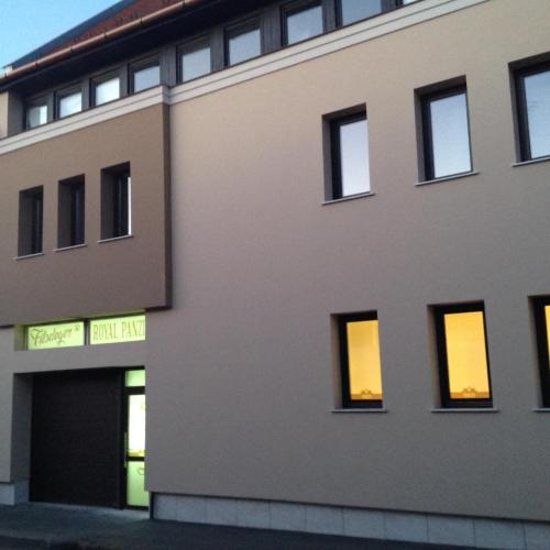 a building with lights in the windows of it at Filsdeger Ház - Central Rooms & Apartmans in Eger